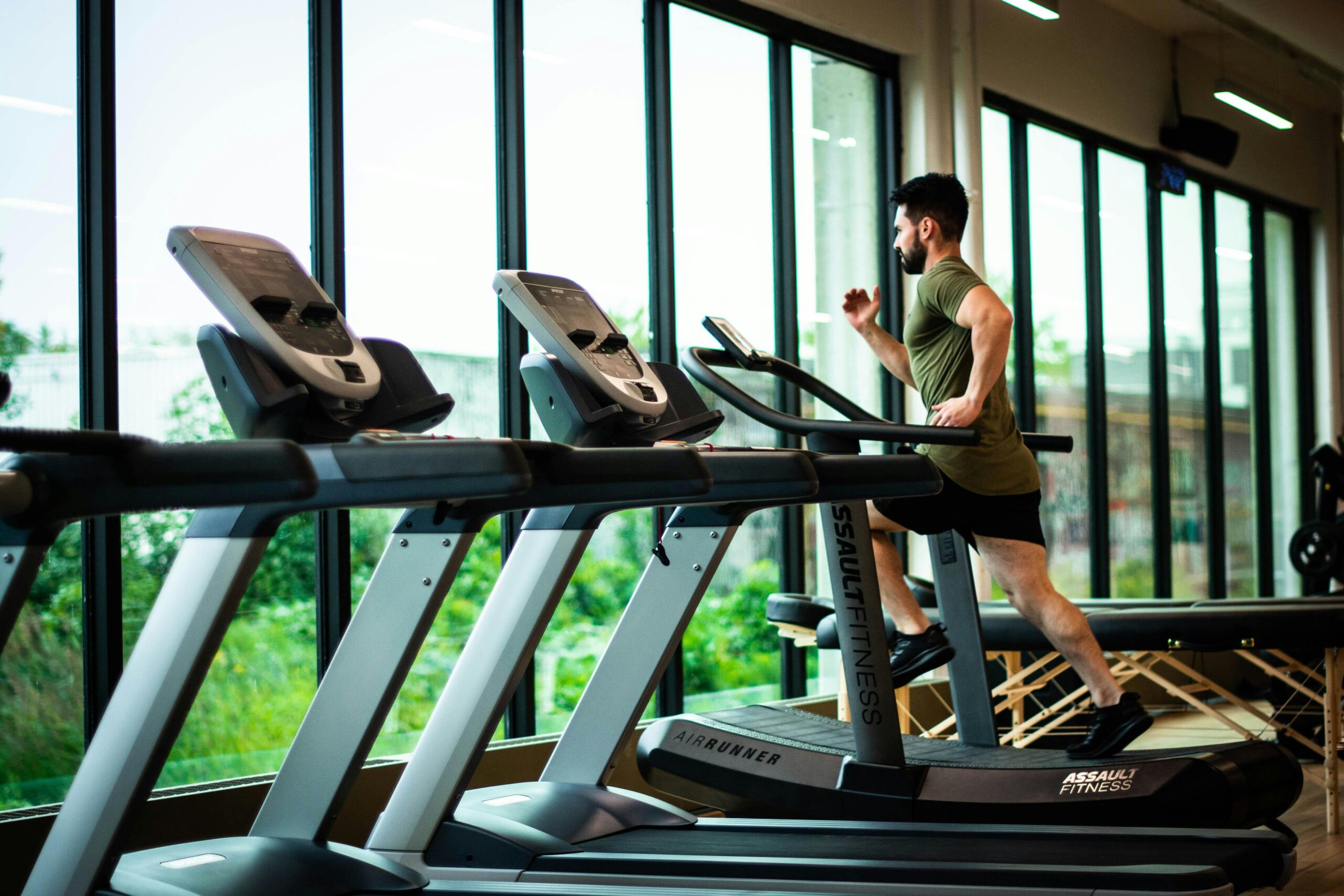pexels-photo-1954524-1954524 Fitness and health Young man workouts on treadmill in modern gym with large windows and natural light.